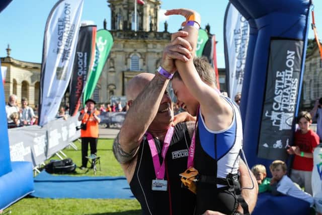 Bailey Matthews 8 from Doncaster is congratulated by his Dad Jonathan after crossing the finish line to complete his first ever triathlon at Castle Howard on sat.