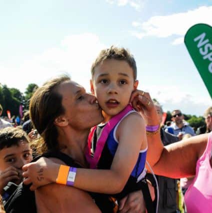 Bailey Matthews 8 from Doncaster gets a kiss from his mother Julia after he crossed the finish line to complete his first ever triathlon at Castle Howard on sat.