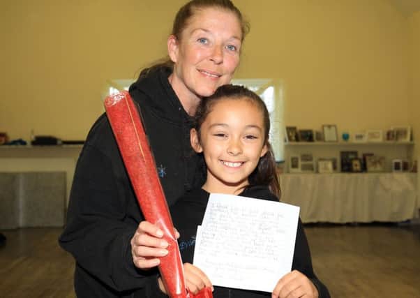 Evie Dennington, eight, presents the Guardian Rose Award to her dance teacher Donna Pressley from the Donna Pressley Dance Academy in Worksop.