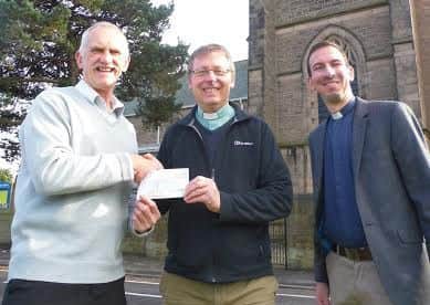 Rev Simon Cash and Luiz Lima of St Annes Church in Worksop present a cheque for £2,000 to Alan Diggles of HOPE