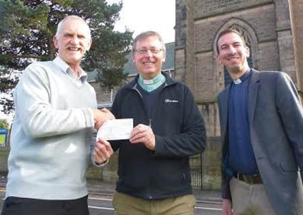 Rev Simon Cash and Luiz Lima of St Annes Church in Worksop present a cheque for £2,000 to Alan Diggles of HOPE