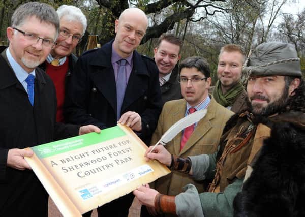 Robin Hood, aka, Ade Andrews,  puts his name to the contract for the RSPB to take over the management of Sherwood Forest Country Park, with from left, Coun. Alan Rhodes, Patrick Candler chief executive of the Sherwood Forest Trus, Coun. John Knight, Kevin Smith Consortium Atractions, Nick Brown from the Thoresby Estate and RSPB area manager, Michael Copleston.
