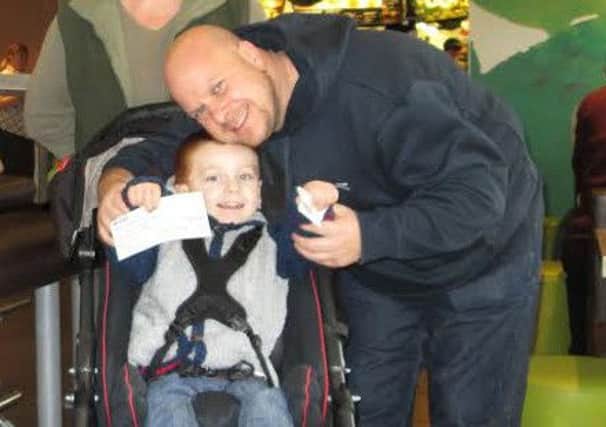 Brandon with his dad Gavin, have reached a halfway milestone in the money they need to raise for building improvements so the youngsters with cerebral palsy can receive care at home