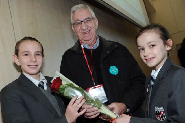 Year 6 pupils, Jay and Maddison, from the Sparken Hill Academy, present Eric Eaton with the Guardian rose at a special assembley on Friday.