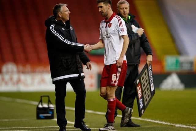 Nigel Adkins shakes hands with the injured Chris Basham as the midfielder is substituted against Swindon Town