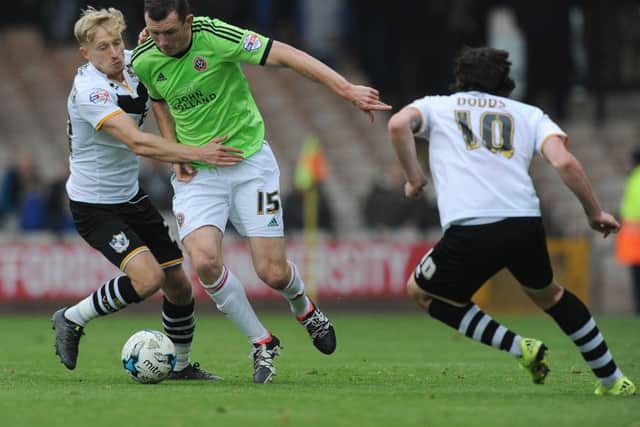 Neill Collins of Sheffield United is challenged by AJ Leith-Smith of Port Vale