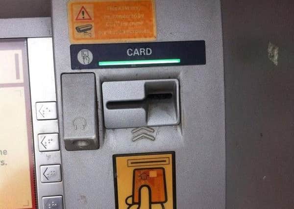 A cash machine with a skimming device fitted.