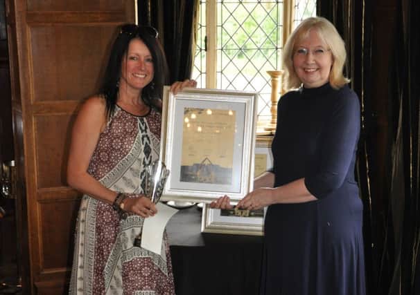 Mandy Coggan (left, receiving her prize from Angela Meads) has won the North Nottinghamshire Short Story Competition