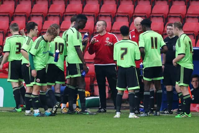 Sheffield United's coach Travis Binnion talks to his team