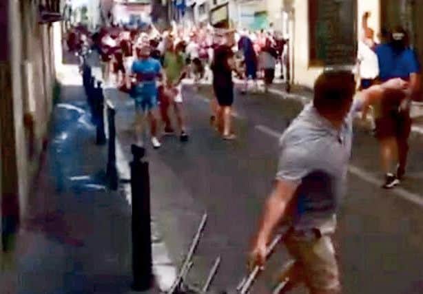 This is the moment a gang of violent Russian thugs apparently goaded English football fans - before an organised troop of 150 yobs "ambushed" the Brits. See SWNS story SWFOOTIE. A stunned England fan said the opposing fans were like an "army" when they targeted him and his friends in an alleyway in Marseille. The video appears to show a few dozen Russian fans pelting bottles at the British travelling fans, causing them to fight back. But the 24-year-old fan from Wigan who took the video said it was part of a well-practised plan, and as soon as England fans reacted they were mobbed. The five-minute long clips shows the Brits being swamped and rushed by the opposing fans, who apparently emerged from hiding in adjoining alleyways. Wearing MMA gloves and masks - including a terrifying 'Scream' face covering - the thugs can be seen pelting bottles before taking cover under chairs to charge forward. Punches are thrown while glass can be heard raining down on the pumped-up English fans in the frightening foota