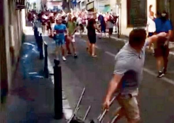 This is the moment a gang of violent Russian thugs apparently goaded English football fans - before an organised troop of 150 yobs "ambushed" the Brits.  See SWNS story SWFOOTIE.  A stunned England fan said the opposing fans were like an "army" when they targeted him and his friends in an alleyway in Marseille.  The video appears to show a few dozen Russian fans pelting bottles at the British travelling fans, causing them to fight back.  But the 24-year-old fan from Wigan who took the video said it was part of a well-practised plan, and as soon as England fans reacted they were mobbed.  The five-minute long clips shows the Brits being swamped and rushed by the opposing fans, who apparently emerged from hiding in adjoining alleyways.  Wearing MMA gloves and masks - including a terrifying 'Scream' face covering - the thugs can be seen pelting bottles before taking cover under chairs to charge forward. Punches are thrown while glass can be heard raining down on the pumped-up English fans in the frightening foota