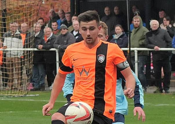 Conor Higginson wearing the armband for Worksop