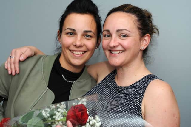 Carla Allen, right, presents the Guardian Rose to her sister Amy Dennington.
