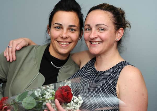 Carla Allen, right, presents the Guardian Rose to her sister Amy Dennington.