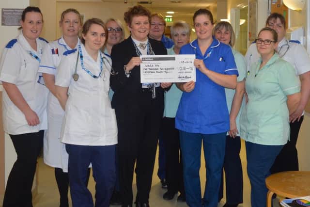 Coun Brand presents the cheque to Corinne James, ward sister, and staff members of A4 ward at Bassetlaw hospital