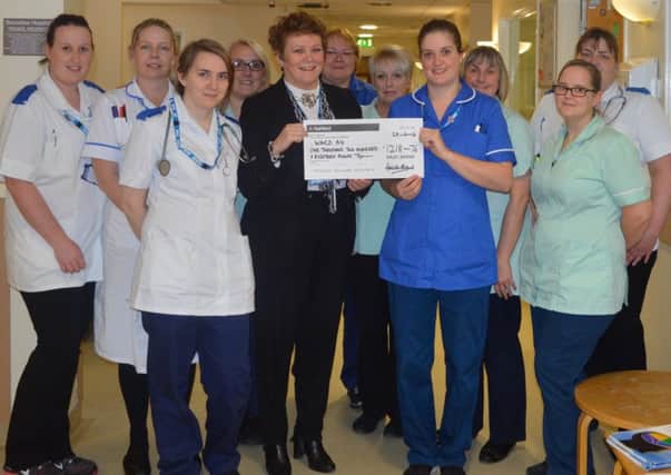 Coun Brand presents the cheque to Corinne James, ward sister, and staff members of A4 ward at Bassetlaw hospital