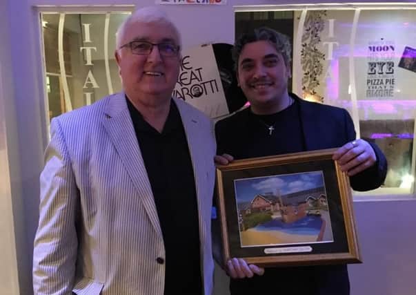 John Bower, chairman of the Worksop Support Group for Bluebell Wood, presenting a framed photo of the hospice to Dario Sollazzo, owner of Italiano