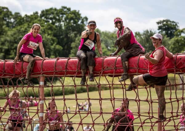 Intrepid women clamber over an A-frame during one of Race For Lifes Pretty Muddy events. (PHOTO BY: Liam McAvoy)