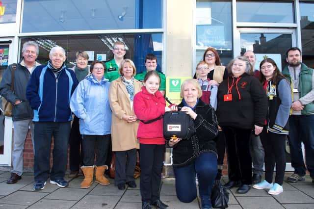 Chairman of the councils Prosperous Communities Committee Coun Sheila Bibb presenting the defibrillator to the volunteers.