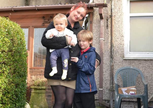Claire Sharpe pictured outside her Fire damaged house with children Oliver, seven and Iris, one