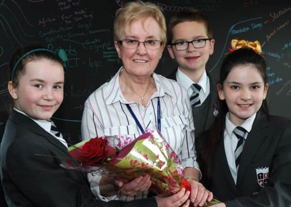 Year six pupils from the Sparken Hill Academy from left, Lucy Hobson, Max Phillipson and Trinity Searles present their retiring lunch-time manager Jenny Lee with the Guardian rose on the last day of term.