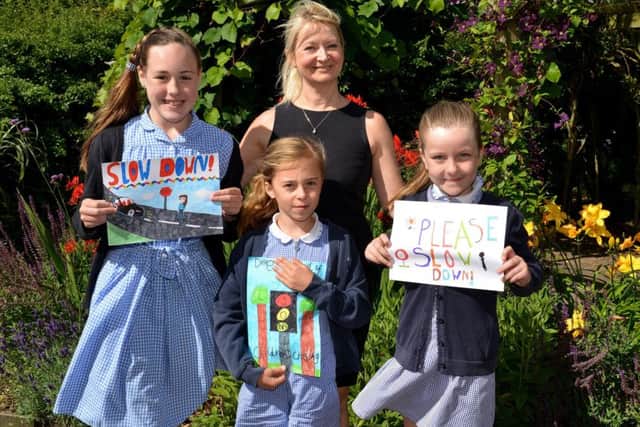 Children at St Peterâ¬"s C of E Primary School took part in a road safety sign competition, pictured are Amy Clapperton, 11, Katy Cowland, seven and Rose Mee, eight with Coun Karen Newsome