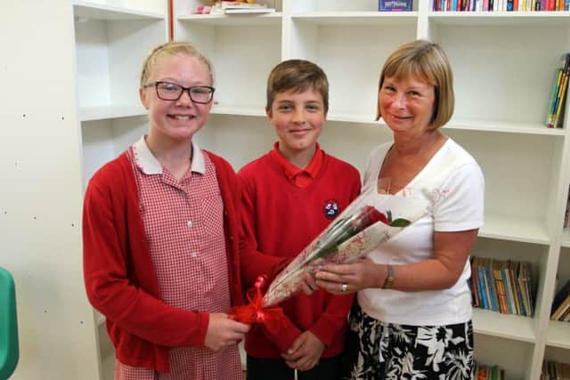 Holly primary pupils Liberty Wright and Lawrence Ellis present the rose to Anne Woodhead.