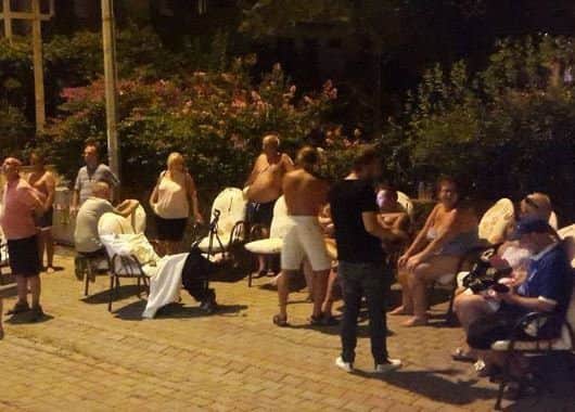 Shocked holidaymakers gather outside Gondol Apartments after the earthquake.
