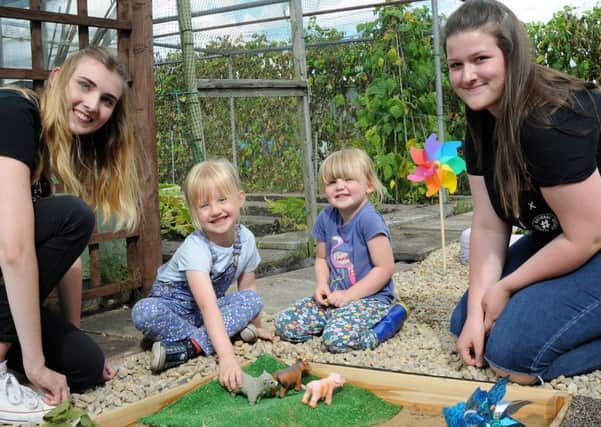 NCS students, Jessica Smith, left and Jess Gibbard keep Martha Hill, 5, and her 3 year old sister Edith, amused in the sand pit during their visit to the revamped allotment site.