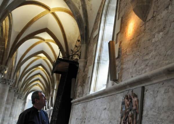 Fr. Nicholas Spicer in the Priory Church where the carved face has been discovered.