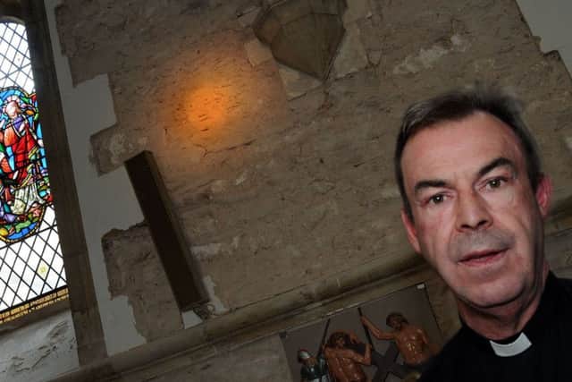 Fr. Nicholas Spicer in the Priory Church where the carved face has been discovered.