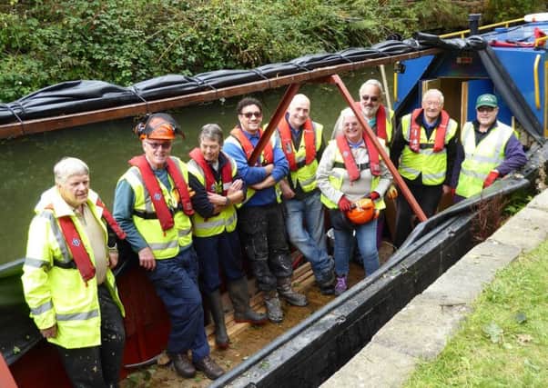 Canal trust volunteers aboard the restored workboat Python during the cutting session