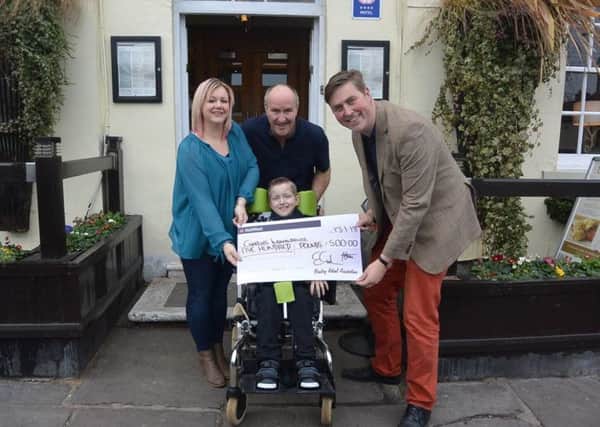 Natalie and Simon Szpakowicz-Cook with son Charlie and Ross Jarvie of the Bawtry Retail Association, which raised Â£500 towards the costs of Charlie's ongoing care at a Christmas event