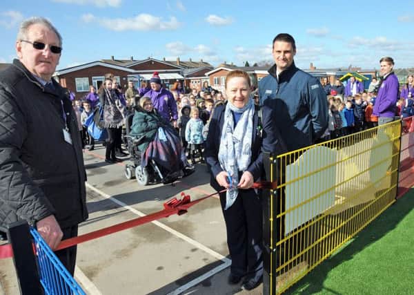 Gainsborough Tesco's Christine Fraser and Daniel Norburn, prepare to cut the ribbon with chairman of Governors, Bill Grant and staff and pupils at the Hillcrest Early Years Academy, to officially open their new all weather sports pitch.