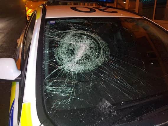 The offenders smashed the window of the police car as they fled the scene