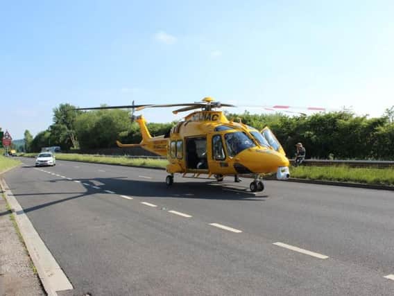 The air ambulance landing on the A57 yesterday. Picture by George Ledwidge.